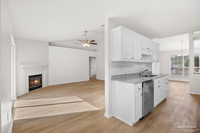 kitchen with dishwasher, ceiling fan with notable chandelier, light wood finished floors, and a sink