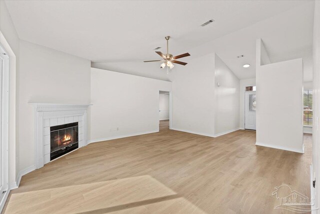 unfurnished living room featuring vaulted ceiling, a ceiling fan, light wood-type flooring, a fireplace, and visible vents