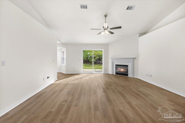 unfurnished living room with wood finished floors, a ceiling fan, and visible vents