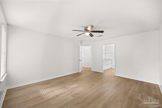 unfurnished room with ceiling fan, baseboards, wood finished floors, and visible vents