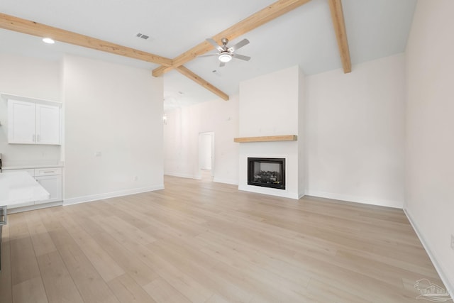 unfurnished living room featuring ceiling fan, beam ceiling, and light hardwood / wood-style flooring