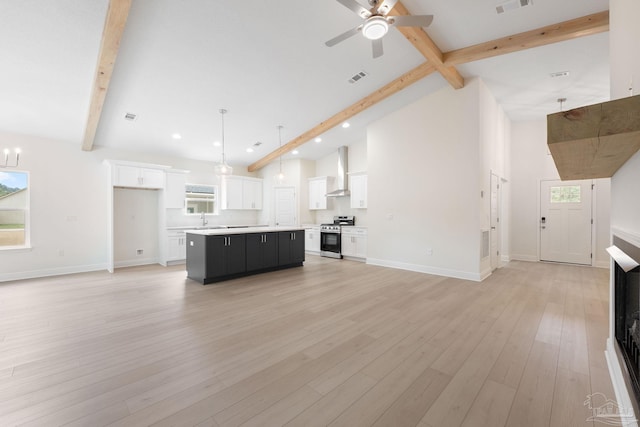 unfurnished living room featuring ceiling fan with notable chandelier, vaulted ceiling with beams, sink, a healthy amount of sunlight, and light wood-type flooring