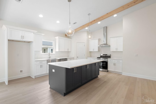 kitchen with wall chimney exhaust hood, white cabinetry, stainless steel appliances, and a center island