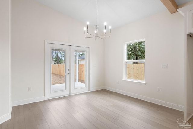 interior space with an inviting chandelier, hardwood / wood-style flooring, plenty of natural light, and french doors