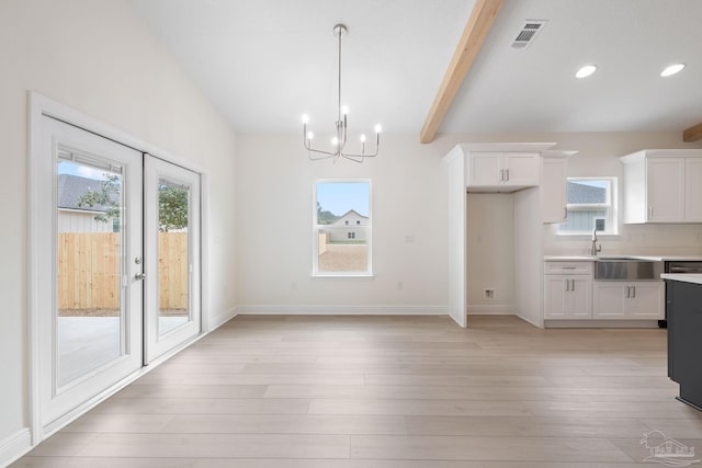 kitchen featuring beam ceiling, white cabinets, decorative light fixtures, french doors, and light wood-type flooring