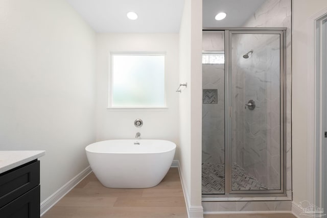 bathroom featuring independent shower and bath, vanity, and plenty of natural light