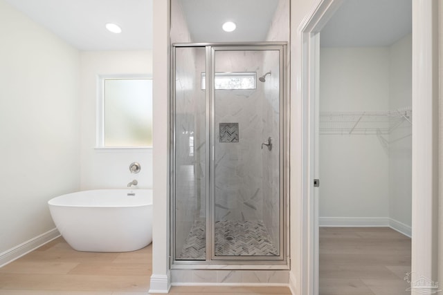 bathroom with hardwood / wood-style floors and shower with separate bathtub