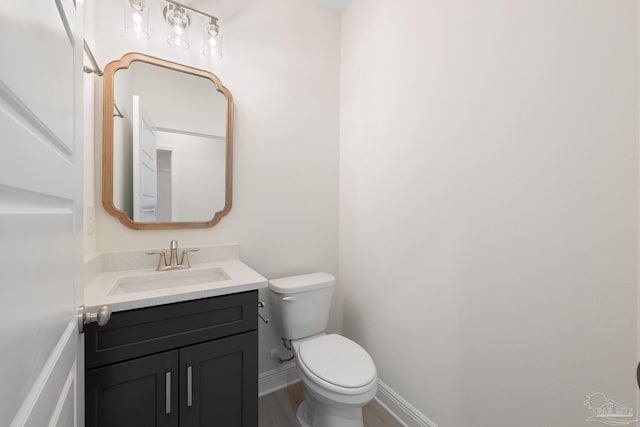 bathroom featuring vanity, wood-type flooring, and toilet