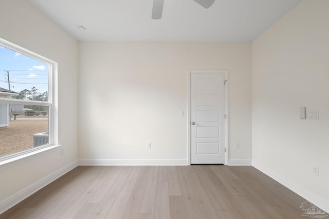 empty room with ceiling fan and light hardwood / wood-style flooring