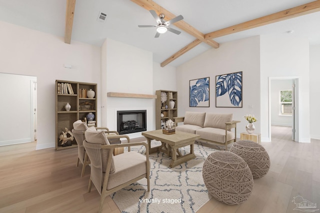 living room with beamed ceiling, ceiling fan, high vaulted ceiling, and light hardwood / wood-style floors