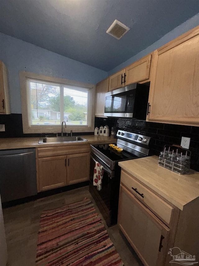 kitchen featuring light brown cabinets, dark wood-type flooring, sink, appliances with stainless steel finishes, and tasteful backsplash