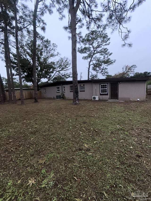 rear view of property featuring a lawn