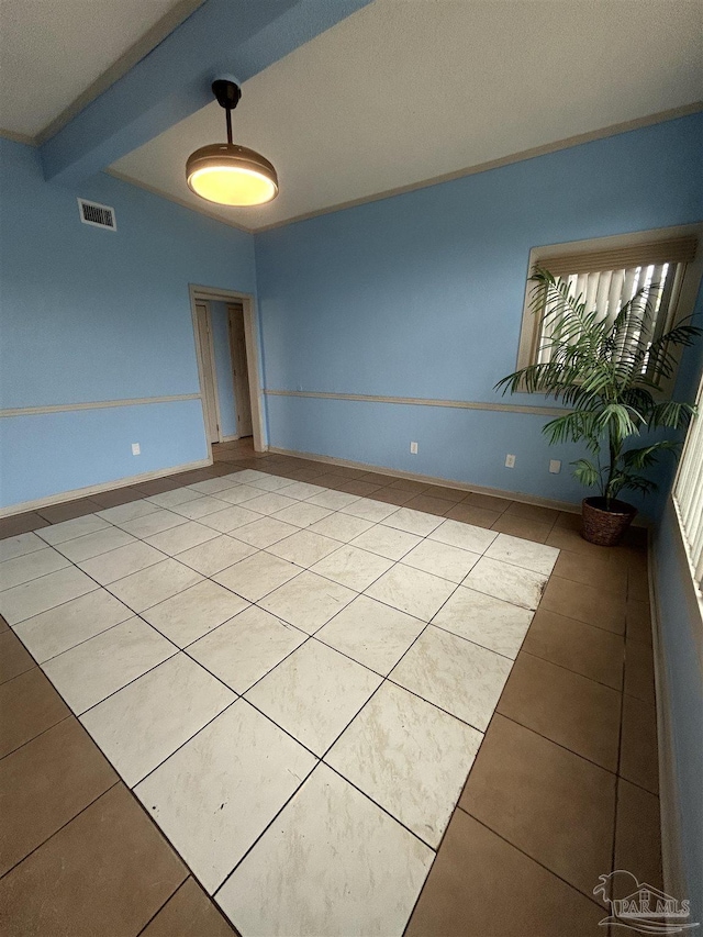 unfurnished room featuring a textured ceiling, lofted ceiling with beams, and tile patterned floors