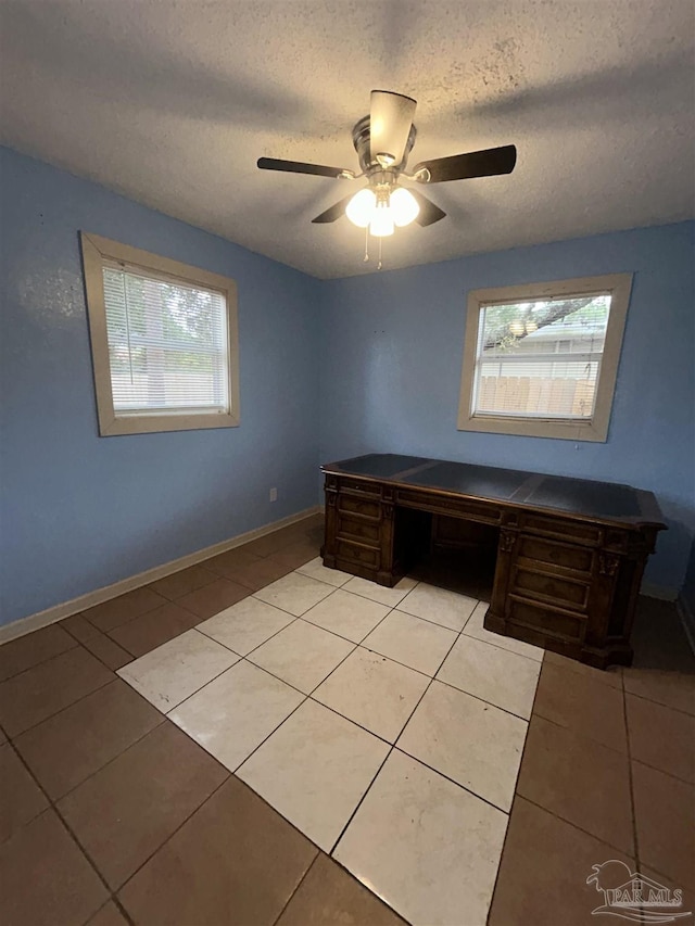 unfurnished office featuring ceiling fan, plenty of natural light, and light tile patterned flooring