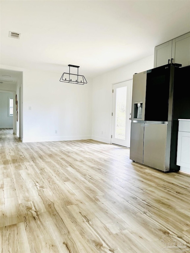 interior space with a wealth of natural light, light wood-type flooring, and visible vents