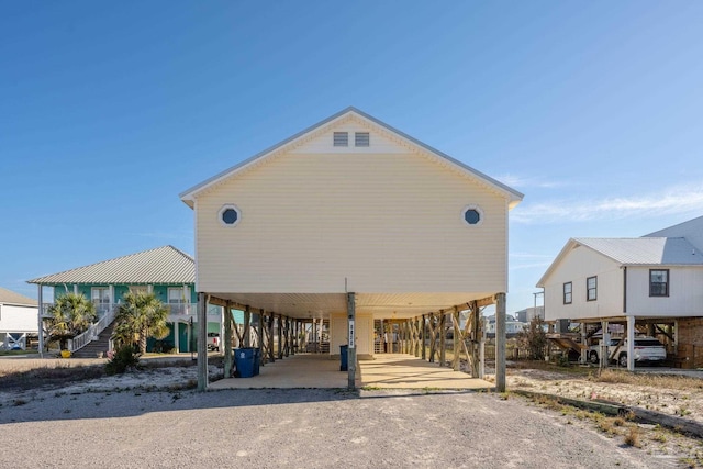 surrounding community featuring stairs, a carport, and driveway