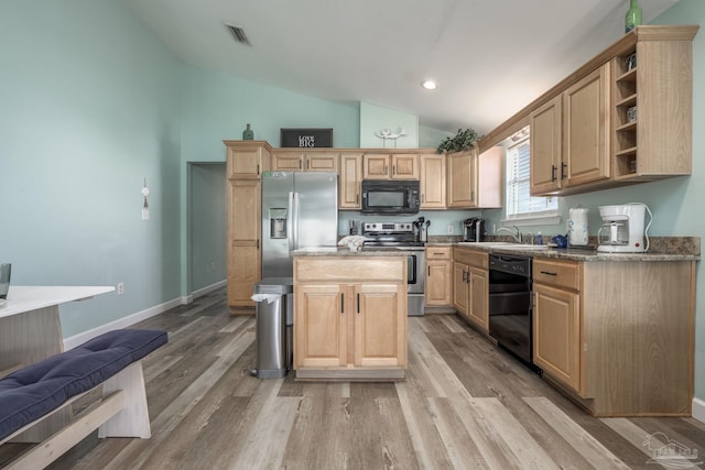 kitchen with light brown cabinets, visible vents, and black appliances