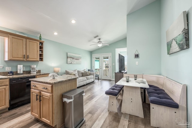 kitchen featuring open floor plan, vaulted ceiling, light wood-type flooring, a center island, and dishwasher