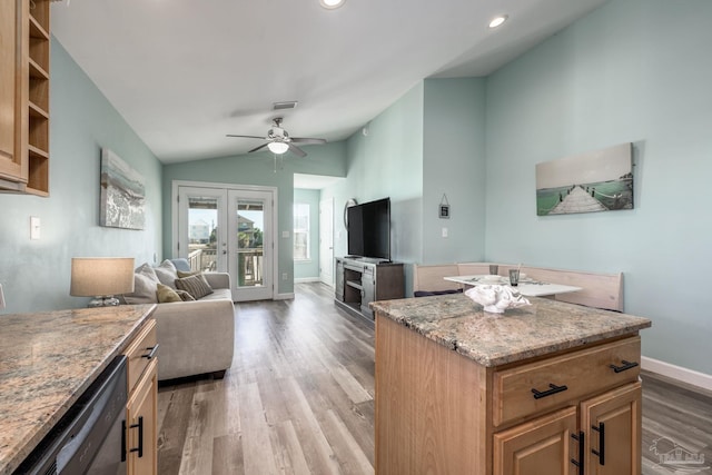 kitchen with lofted ceiling, light wood-style floors, french doors, light stone countertops, and dishwasher