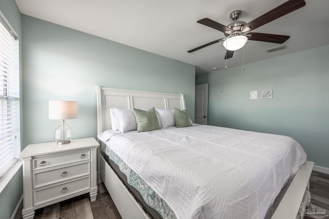 bedroom featuring ceiling fan, dark wood-type flooring, visible vents, and baseboards