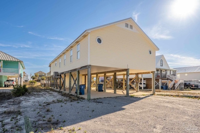 rear view of house with stairs, a carport, and driveway