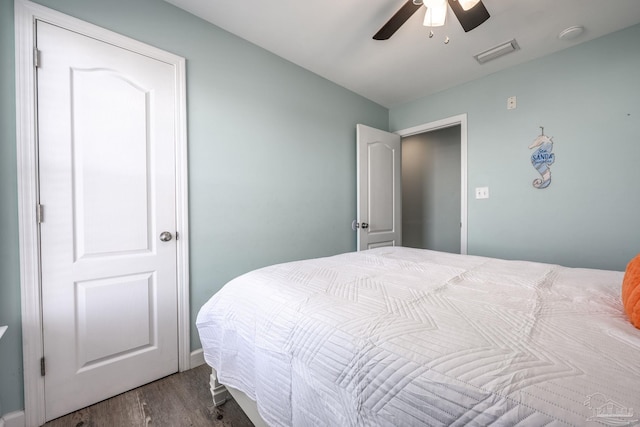 bedroom featuring ceiling fan, wood finished floors, and visible vents