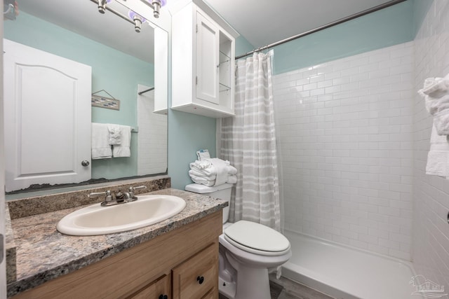 full bath with a stall shower, vanity, toilet, and wood finished floors