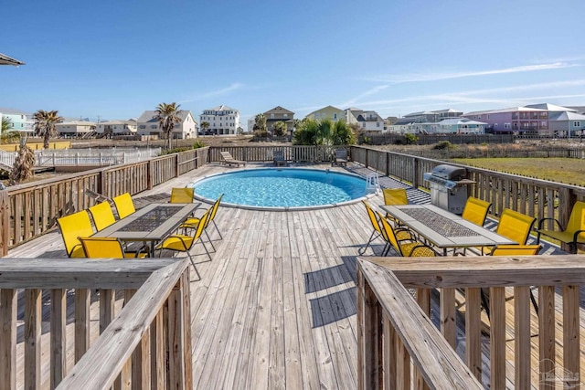 view of swimming pool featuring a fenced in pool, a deck, and grilling area