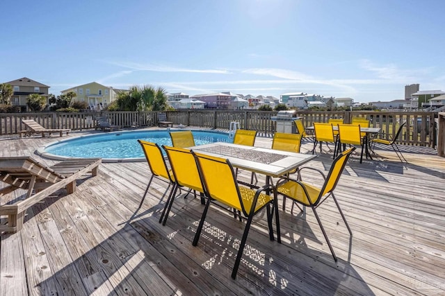 view of pool featuring a fenced in pool, outdoor dining area, and a deck