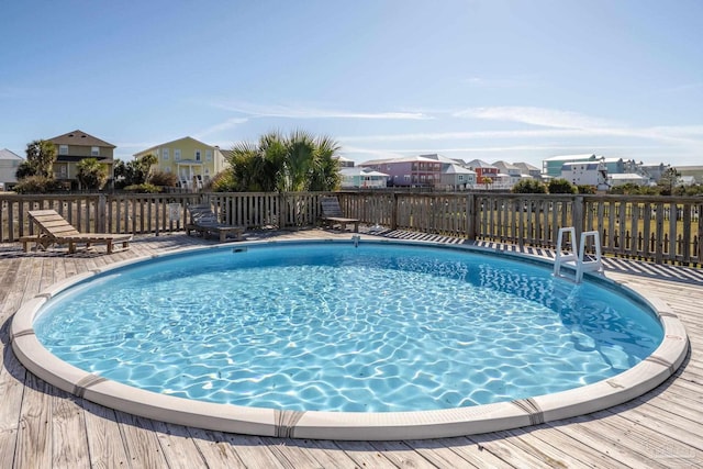 view of swimming pool featuring a fenced in pool, a residential view, and a wooden deck