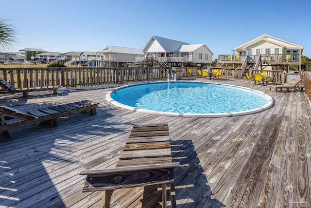 view of swimming pool featuring a residential view, a fenced in pool, and a wooden deck