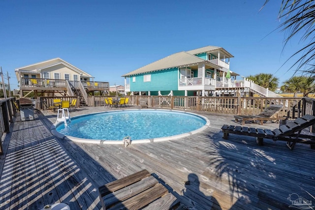 view of pool featuring a fenced in pool, stairway, and a deck