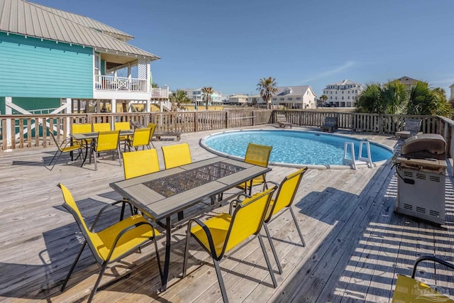 view of swimming pool featuring a fire pit, a fenced in pool, and a wooden deck