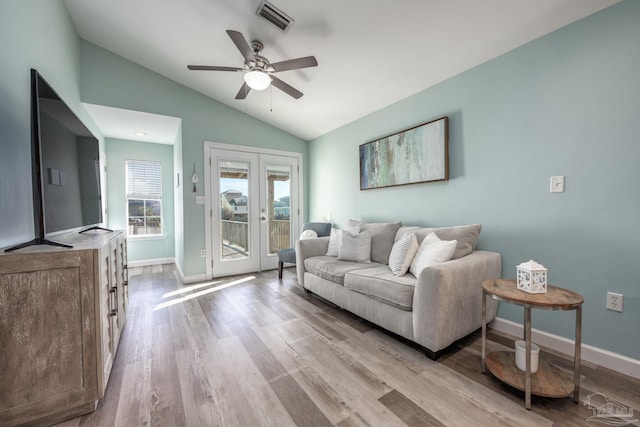 living area with baseboards, visible vents, lofted ceiling, wood finished floors, and french doors