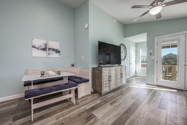 interior space featuring baseboards, vaulted ceiling, and wood finished floors