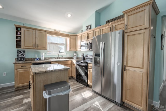 kitchen featuring a kitchen island, light wood-type flooring, black appliances, light brown cabinets, and a sink