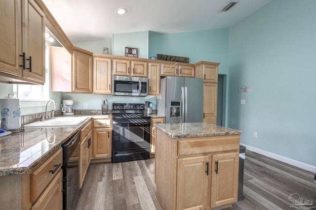 kitchen featuring light brown cabinets, black appliances, a sink, and visible vents