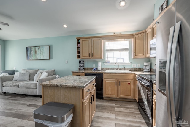 kitchen featuring light brown cabinets, a sink, and black appliances