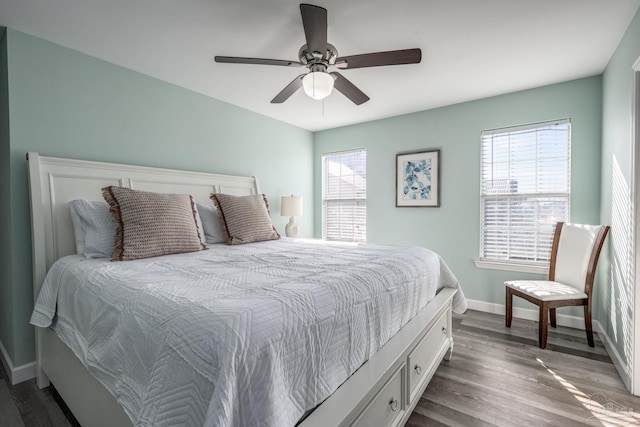 bedroom featuring ceiling fan, baseboards, and wood finished floors