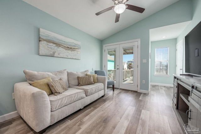 living area featuring vaulted ceiling, light wood-style flooring, baseboards, and ceiling fan