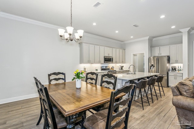 dining room with visible vents, recessed lighting, crown molding, and light wood-type flooring