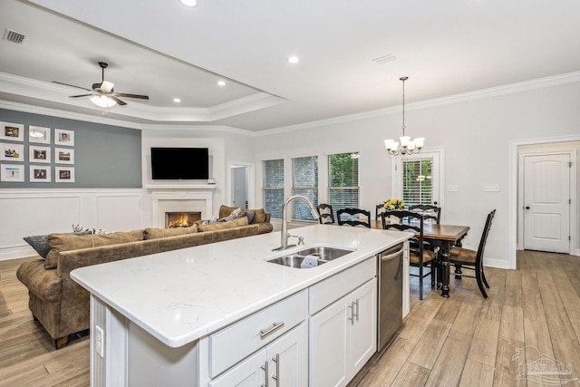 kitchen with a sink, ornamental molding, light wood-style flooring, and visible vents