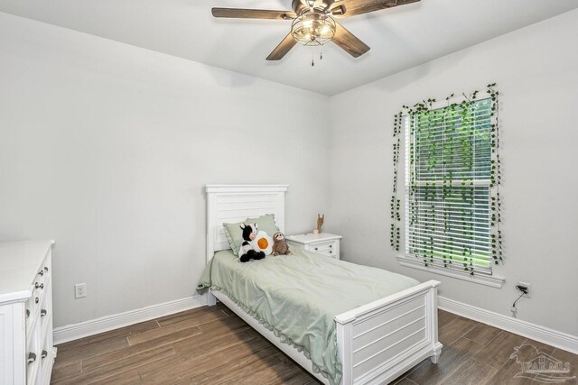 bedroom with baseboards, ceiling fan, and dark wood-type flooring