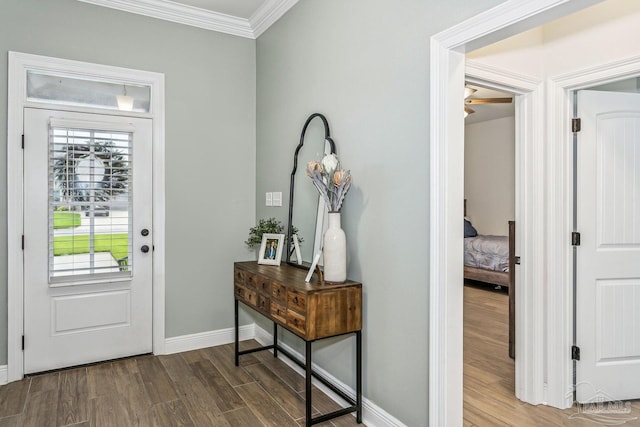 entrance foyer with crown molding, baseboards, and wood finished floors