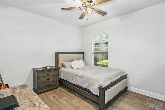 bedroom with a ceiling fan, baseboards, and wood finished floors