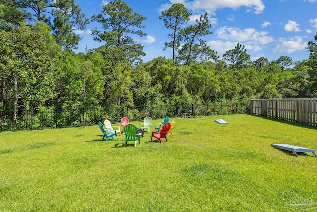 view of yard featuring fence and a wooded view