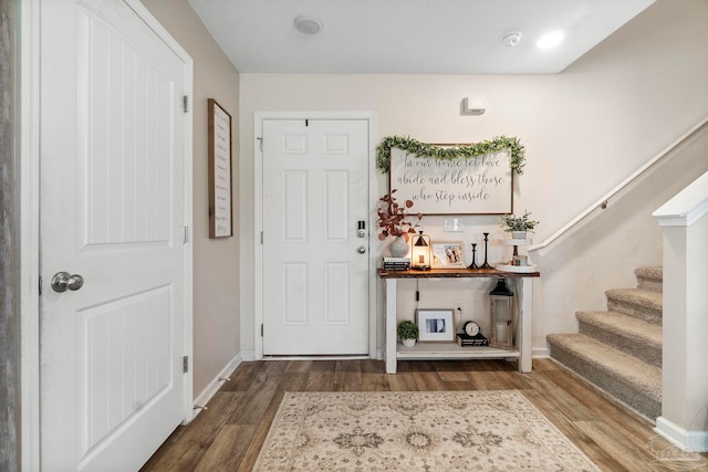 entrance foyer featuring baseboards, stairway, and wood finished floors