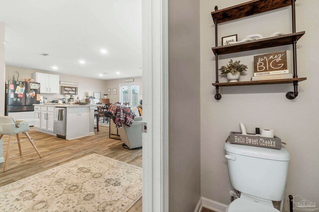 bathroom with vanity, toilet, and hardwood / wood-style floors