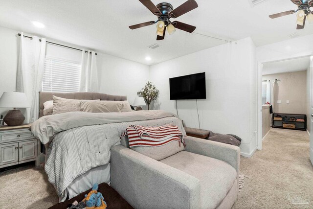 carpeted bedroom featuring multiple windows and ceiling fan