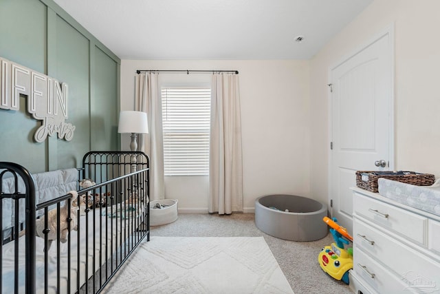 bedroom featuring a nursery area and baseboards